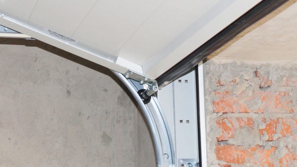 parts of a garage door Builder-grade plastic garage door rollers on a track