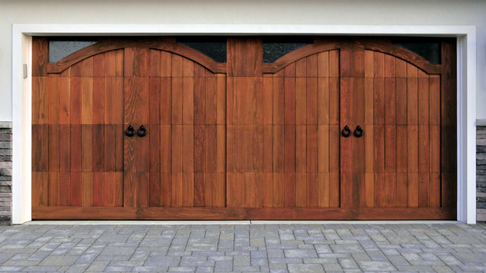 A beautiful custom garage door with a rich wood finish adds style to a home.