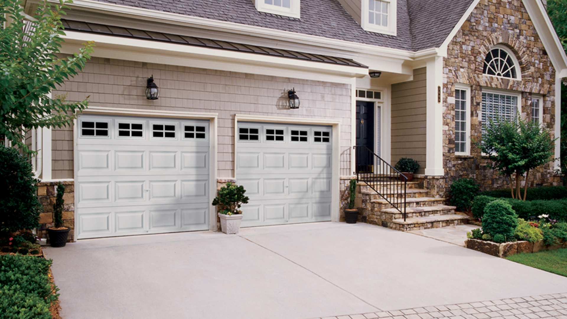 Home with new double garage doors after replacement.